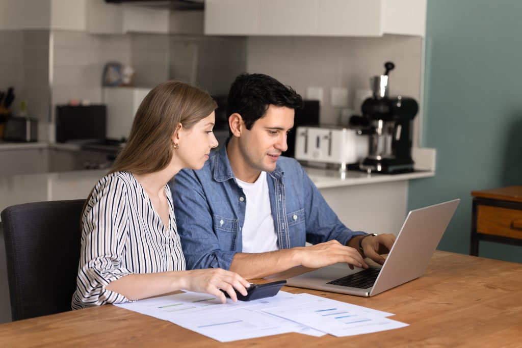 Focused young married couple managing family budget